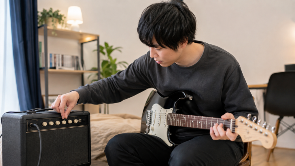 初心者が小型ギターアンプのつまみを調整して音作りする様子